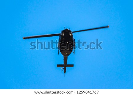 The helicopter is flying in the blue sky. Aircraft Transportation. Military helicopter flying in the blue sky.