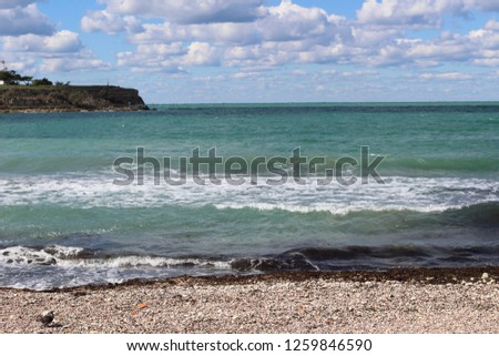 Sea waves are crashing on the shore. Superb seascape with turquoise black sea water. Crimean coast near the city of Sevastopol