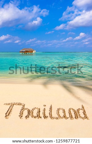 Word Thailand on beach - concept holiday background