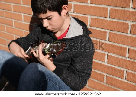 teenager playing ukulele in a bad mood