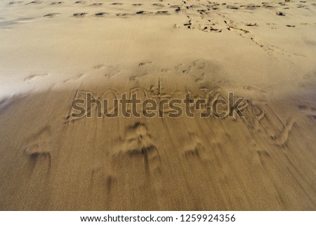 The picture on the sand in the Crand Canaria beach. Ocean wave washed away the inscription "Do not worry"