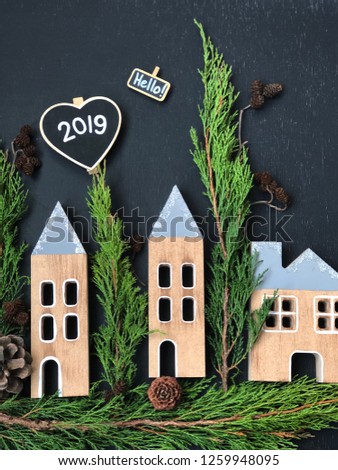 small christmas wooden houses on black background with chalkboards for your text