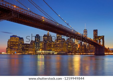 Brooklyn Bridge with the New York City skyline in the background, photographed at dusk.