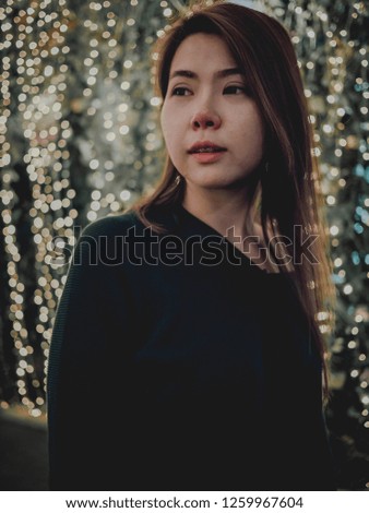 Night street portrait of beautiful young woman. Festive Christmas bokeh lights.