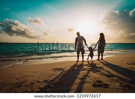 happy family with two kids on play on sunset beach