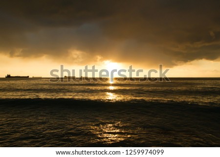 Cargo ships at sunset on the sea. Reflection of the sun's rays in the nautical fashion.