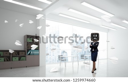 Business woman in suit with an old TV instead of head keeping arms crossed while standing among flying paper planes inside office building. 3D rendering.