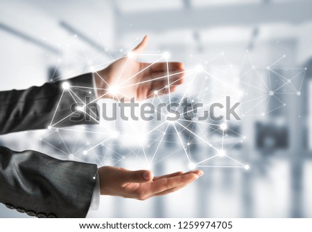 Business woman in suit keeping white social media network structure in hands with office view on background. Mixed media.