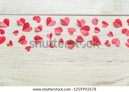 Plenty of cut out paper red hearts on wooden backround. Handmaede decoration for Valentine's day. 