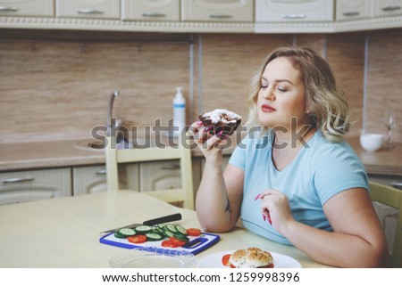 Young pretty fat blond woman prepared to eat a cupcake. The concept of healthy eating, diet, the fight against obesity.