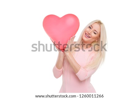 Beautiful young blond woman with heart shape pink air balloon on white isolated background. Woman on Valentine's Day. Symbol of love - Image. Space for text