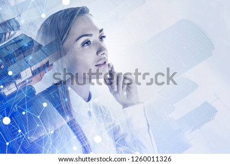 Portrait of thoughtful young businesswoman in white shirt over cityscape background with glowing network hologram. Toned image double exposure mock up
