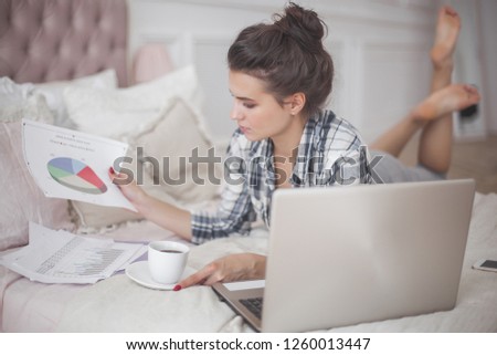 Young woman woking at the computer at home. Female typing. Freelancer working at laptop. Distant job.