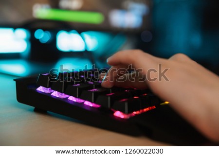 Close up of a woman's hand typing on a gamer keyboard