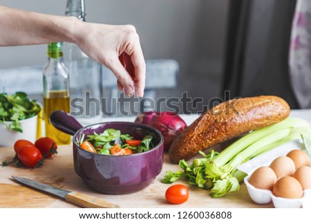hands of chefs prepare a salad of fresh and healthy ingredients, vegetables and olive oil in the kitchen . culinary and food concept