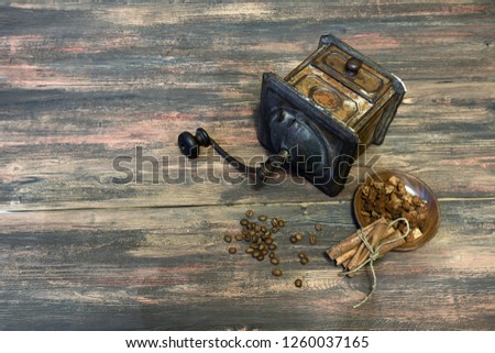 Old metallic copper coffee grinder on the wooden table background