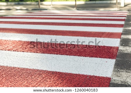 red and white pedestrian crossing over the street in the city