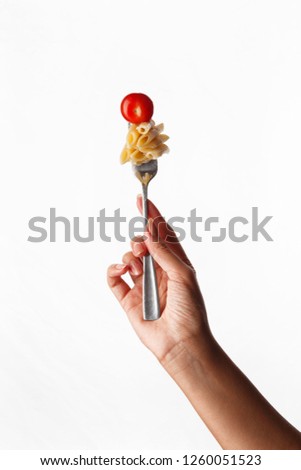 
pasta on a fork in hand on white background Royalty-Free Stock Photo #1260051523