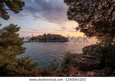 castle on an island in the sea at sunset