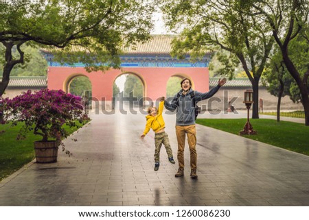 Dad and son are tourists on the background of the large Chinese gates. Travel with children in China concept