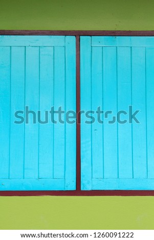 Blue wooden windows for closing and opening for ventilation and air to enter the house or room to prevent germs, mold, damp on the cement background wall.