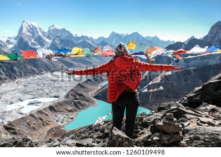 Woman standing on the top of Gokyo Ri, Himalaya, Nepal Royalty-Free Stock Photo #1260109498