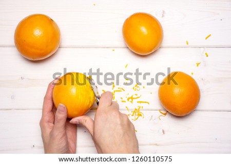 Woman hands are scraping orange zest. recipe step by step hot red mulled wine flatlay on white wood