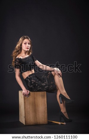 Girl sitting  on the percussion musical instrument kahon, in the studio