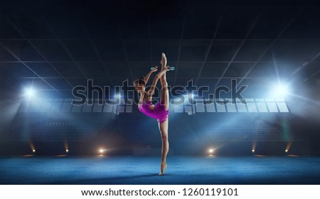 Beautiful rhythmic gymnast in professional arena.