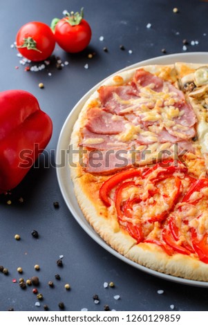 Cooked pizza on dark background with ingredients, closeup