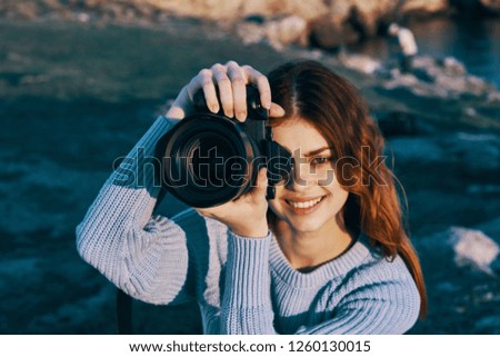 Smiling woman with a camera in nature              