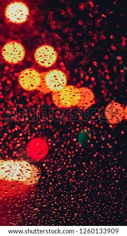 Rain drops on car window. night at car when raining outside. Water drops on glass. Surface of wet glass. City lights bokeh during the rain. for Instagram mobile story or stories size. Mobile wallpaper