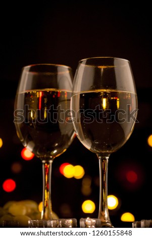 White sweet wine in groceries on a black background. Holiday Bokeh