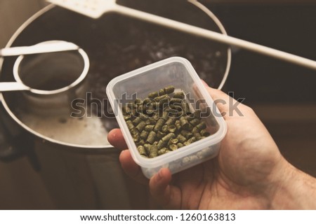 A man brewing craft beer in a kitchen. Home brewing concept image. 