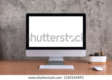 Blank screen of all in one computer with cactus vase on raw concreate background
