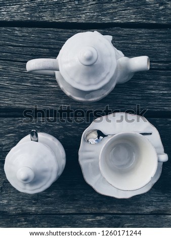 Top view of white vintage tea ware at wooden table at background