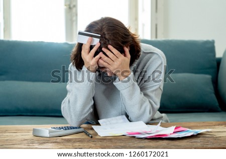 Young attractive woman looking stressed and worried with card payments and home finances accounting costs charges taxes and mortgage in paying bills financial problems and credit card debts concept. Royalty-Free Stock Photo #1260172021