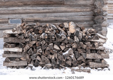 a stack of firewood in the winter yard