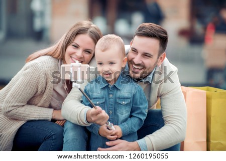 Happy family.Father,mother and son in the city take selfie and have fun.