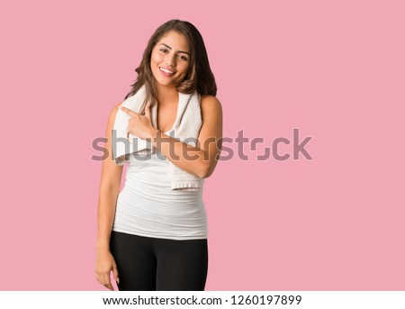 Full body young fitness curvy woman smiling and pointing to the side