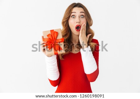Image of a beautiful shocked emotional woman in christmas costume holding present gift box.