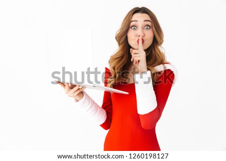 Picture of a pretty excited woman in christmas costume using tablet computer showing silence gesture.