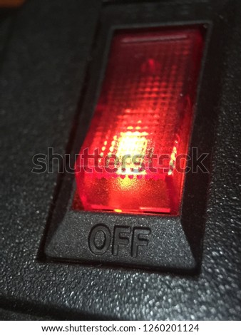 Close up switch off with red light on black background.