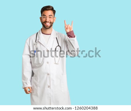 Young doctor man doing a rock gesture
