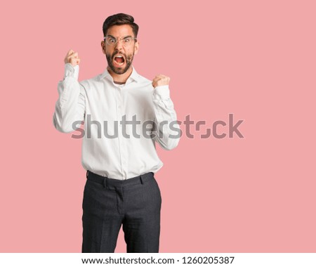 Young handsome business man screaming very angry and aggressive
