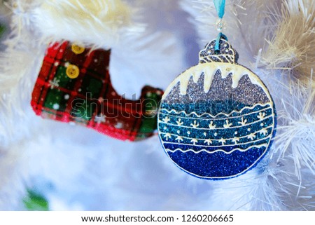 Christmas red boot and round blue toy on the background of a white Christmas tree, the theme of the holidays and the new year
