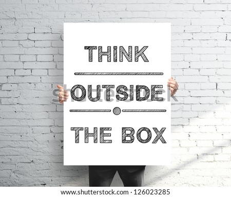 businessman holding poster with think outside the box