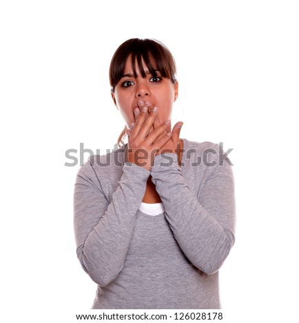 Portrait of a surprised young woman with fringes looking at you on gray t-shirt against white background