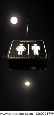 A signpost to the men's and women's toilets in a mall