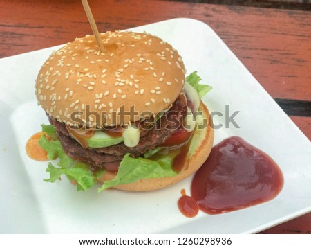 close up of homemade hamburgers with ketchup on white plate